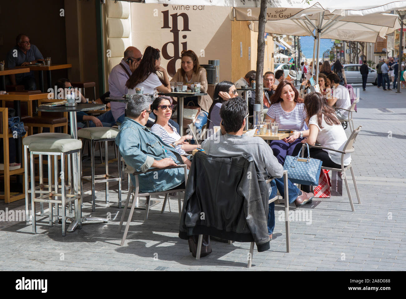 Heraklion, Kreta, Griechenland. Kunden entspannen in einem beliebten Stadtzentrum Straßencafé. Stockfoto