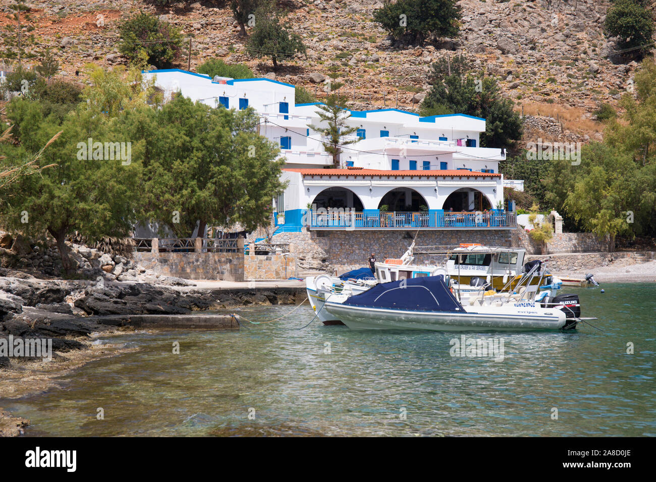 Loutro, Chania, Kreta, Griechenland. Blick über die ruhige Bucht auf den Old Phoenix, ein Hotel und Restaurant am Wasser im kleinen Weiler Finix. Stockfoto