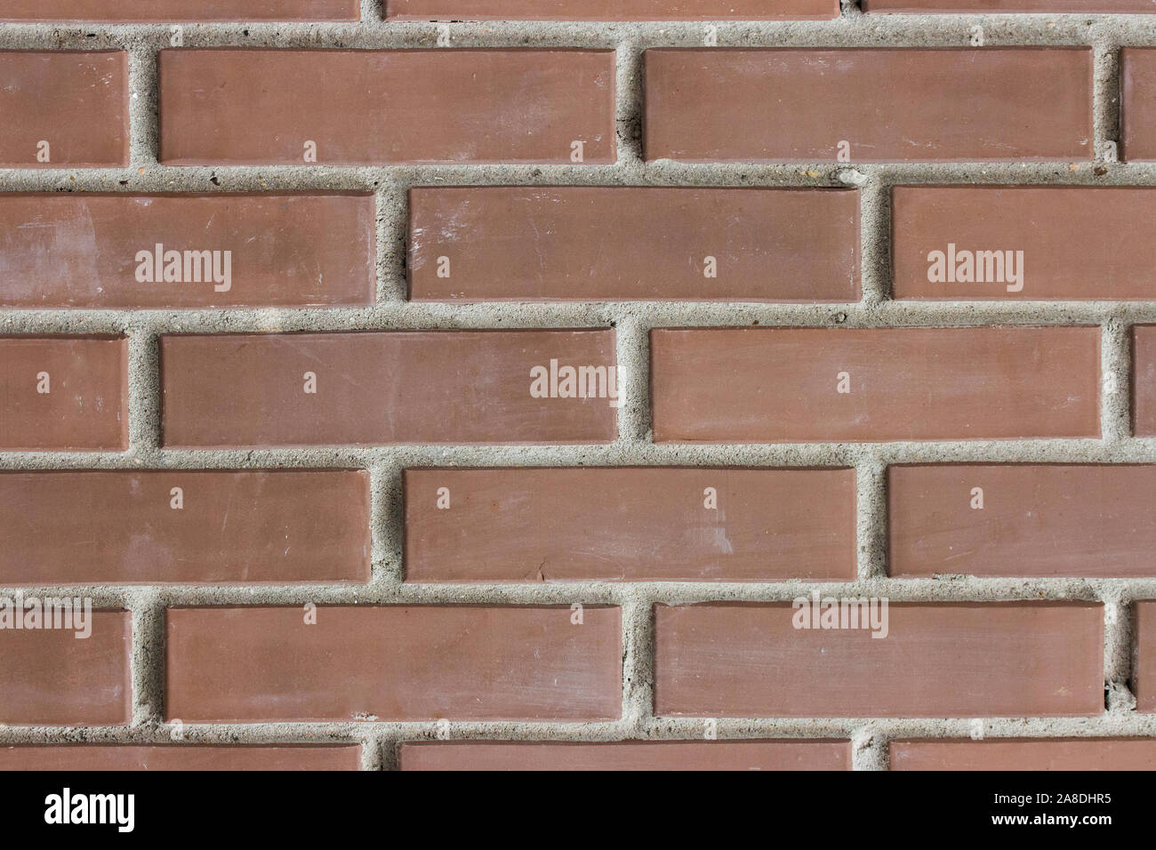 Braun rötlich dunklen Backstein, Textur Hintergrund. Baumaterial für die Außenwände von Gebäuden. Mauerwerk Schach eine Reihe von Backsteinen mit Stockfoto