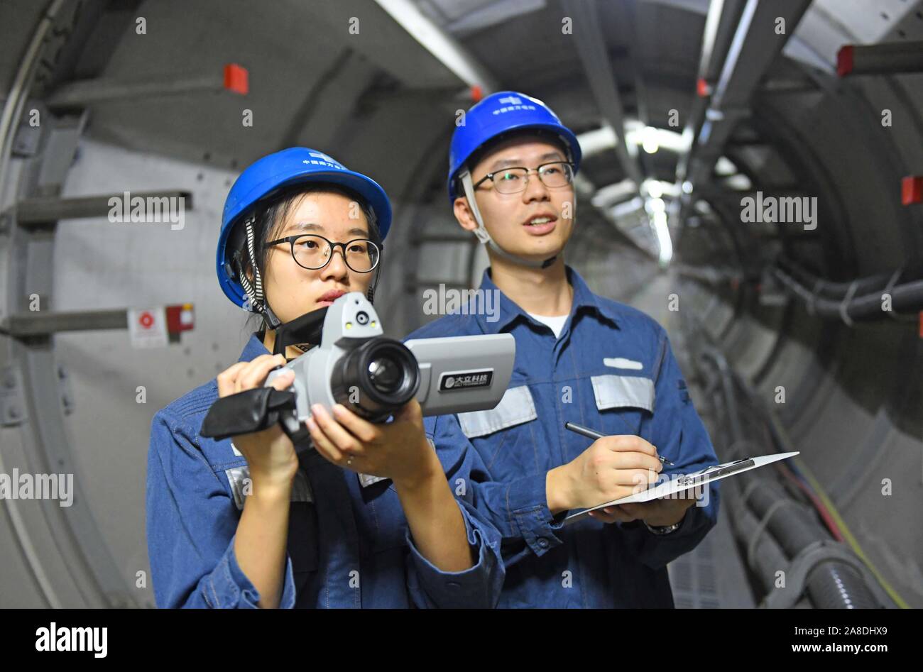 Chinesische Arbeiter aus der lokalen Stromversorgung Präsidium Patrol und 220 kv-höchstspannungsleitung Stromkabel unterirdisch in Foshan City, South China' befestigt prüfen Stockfoto