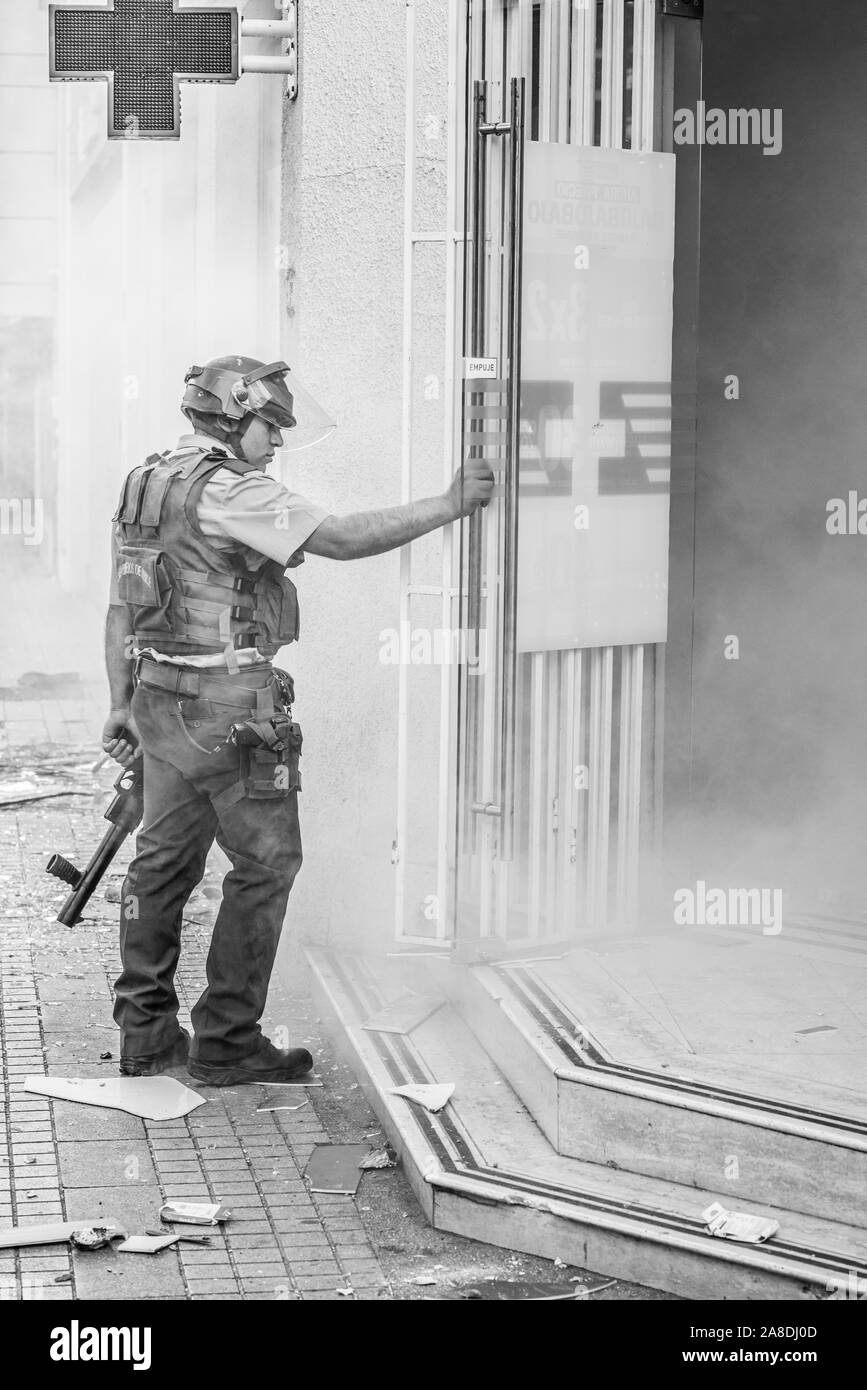 Der antiago de Chile Chile 6 November 2019 Polizist befasst sich mit einem kleinen Geschäft geplündert bei Providencia neighborhood während der jüngsten Unruhen Stockfoto