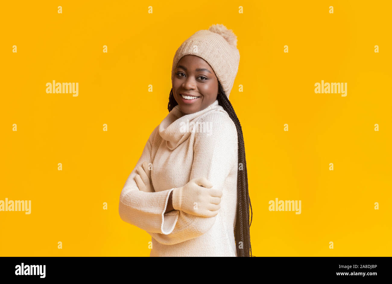 Gefrorene winter schwarze Mädchen lächelnd über Gelb studio Hintergrund Stockfoto
