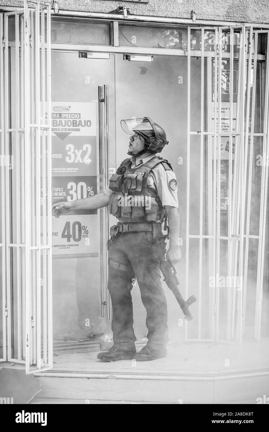 Der antiago de Chile Chile 6 November 2019 Polizist befasst sich mit einem kleinen Geschäft geplündert bei Providencia neighborhood während der jüngsten Unruhen Stockfoto