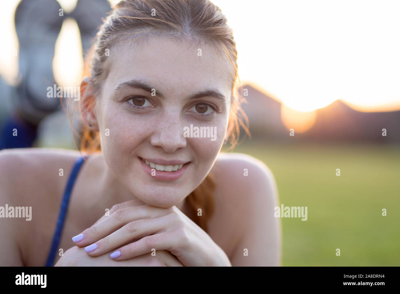 Close up Portrait von freundlich lächelnden jungen Mädchens mit Sommersprossen in ihrem Gesicht draußen in den sonnigen Sommertag. Menschlichen Ausdrucksformen und Emotionen Konzept. Stockfoto