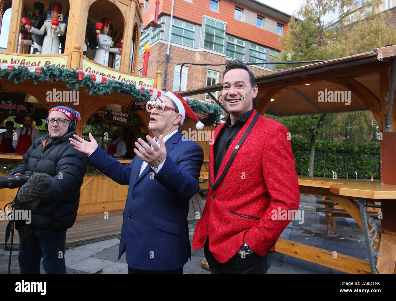 Manchester, Großbritannien. 8. November 2019. TV-Persönlichkeit und streng Come Dancing Richter, Craig Revel Horwood der Weihnachtsmarkt öffnet neben Stadtrat Pat Karney. Craig erscheint in der Pantomime in der Stadt jetzt und die sieben Zwerge' an der Oper im Dezember. Craig besucht das Eis Dorf und mit einigen der Eisskulpturen aufgeworfen. Eis Dorf, Kathedrale, Manchester, Lancashire, UK. Quelle: Barbara Koch/Alamy leben Nachrichten Stockfoto