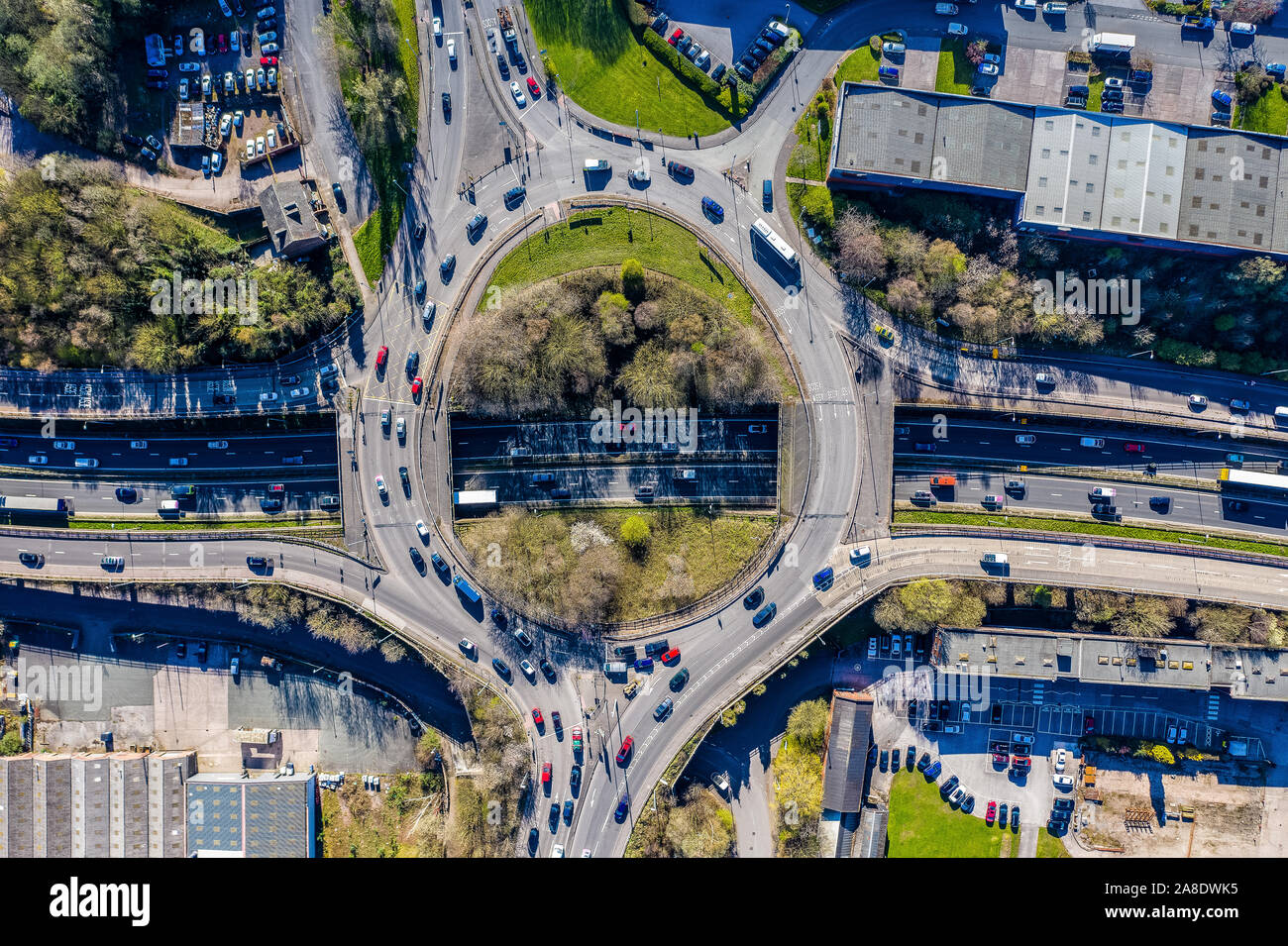 Overhead, Luftbilder von einem Kreisverkehr bei rush hour, besetzt mit Verkehr pendeln zu und von der Arbeit, Schulen, Kindertagesstätten und anderen Leben braucht Stockfoto