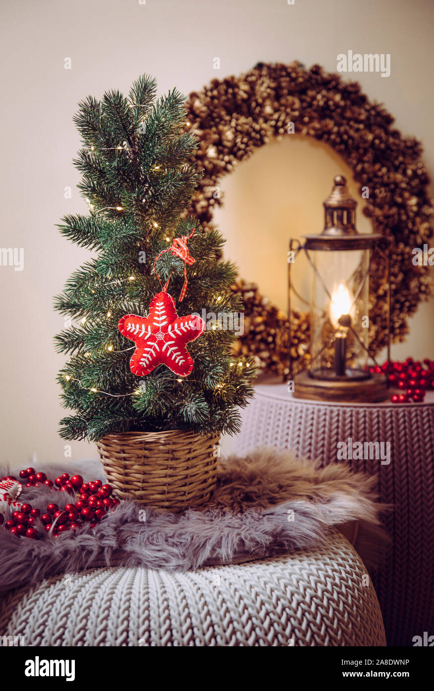 Kleine tragbare Tischplatte geschmückten Weihnachtsbaum auf dem Tisch, party Leuchten, rotem Filz Stoff Ornament. Lampe Laterne mit Pine Cone wreat Stockfoto