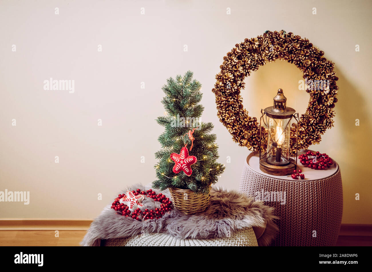 Kleine tragbare Tischplatte geschmückten Weihnachtsbaum auf dem Tisch, party Leuchten, rotem Filz Stoff Ornament. Lampe Laterne mit Pine Cone wreat Stockfoto