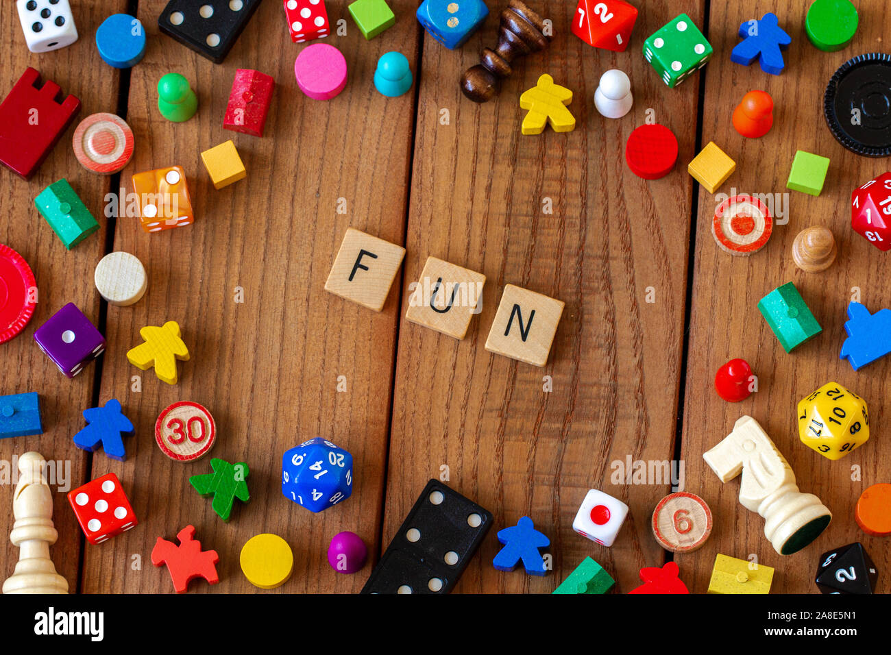 "Fun" in Holz- Brief Fliesen geschrieben. Durch würfeln, Karten umgeben, und andere Spielsteine auf einem hölzernen Hintergrund Stockfoto