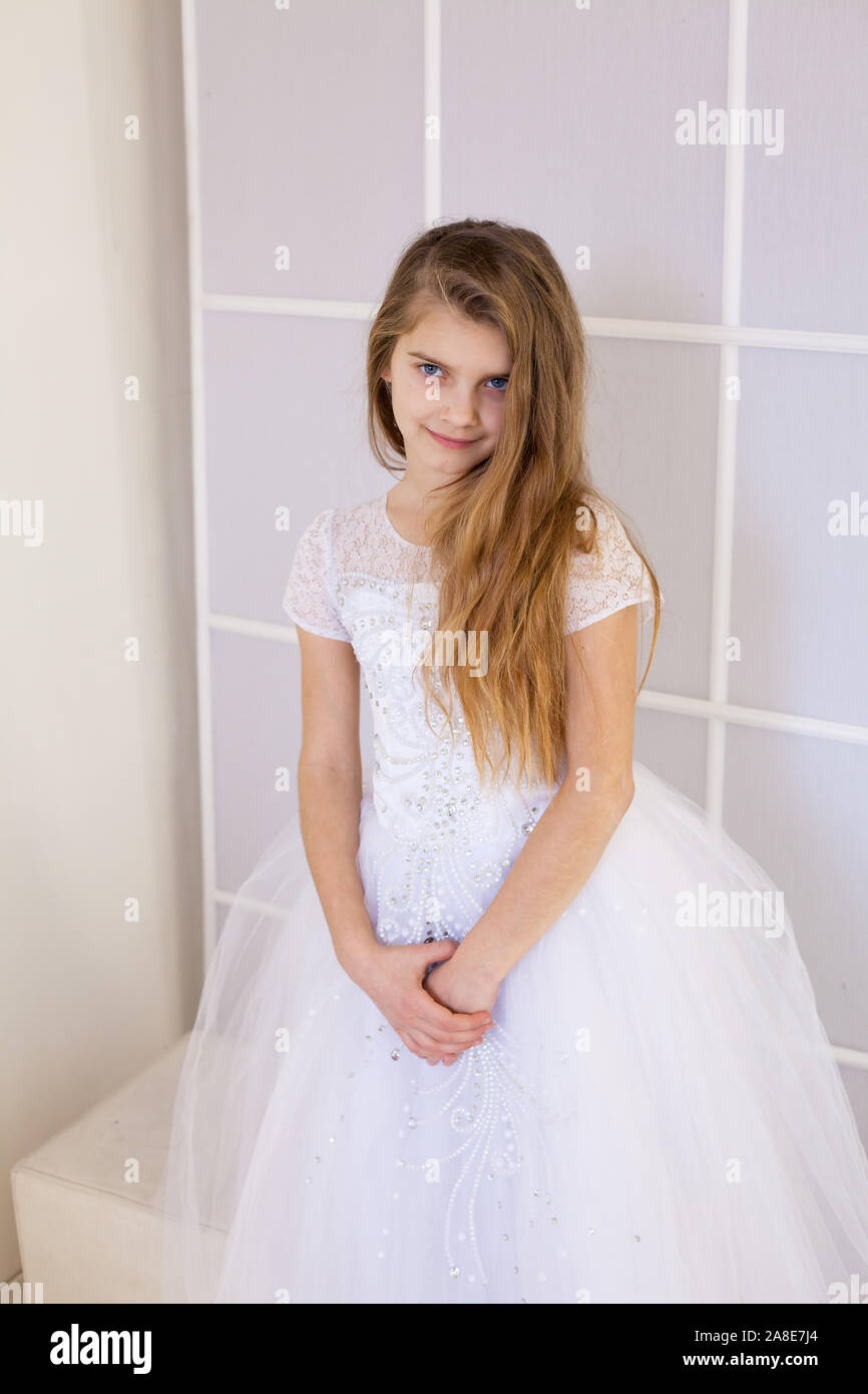 Mädchen von zwölf Jahren in einem wunderschönen weißen Kleid Stockfoto