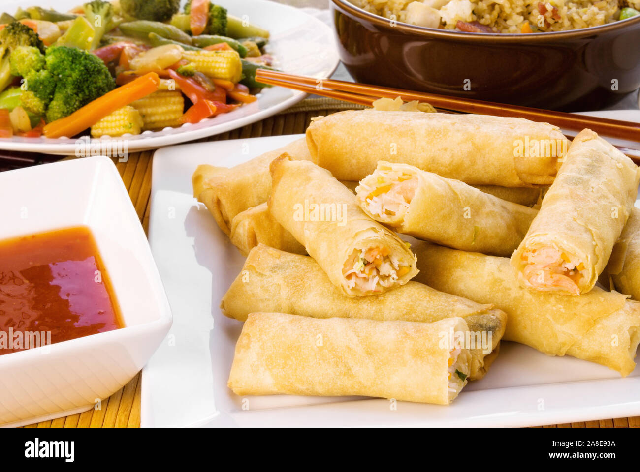 Garnelen Frühlingsrollen serviert mit asiatischen Braten und Geflügel rühren gebratener Reis mit Gemüse. Einen süßen Soße ist im Preis inbegriffen. In natürlichen Tag geschossen Stockfoto