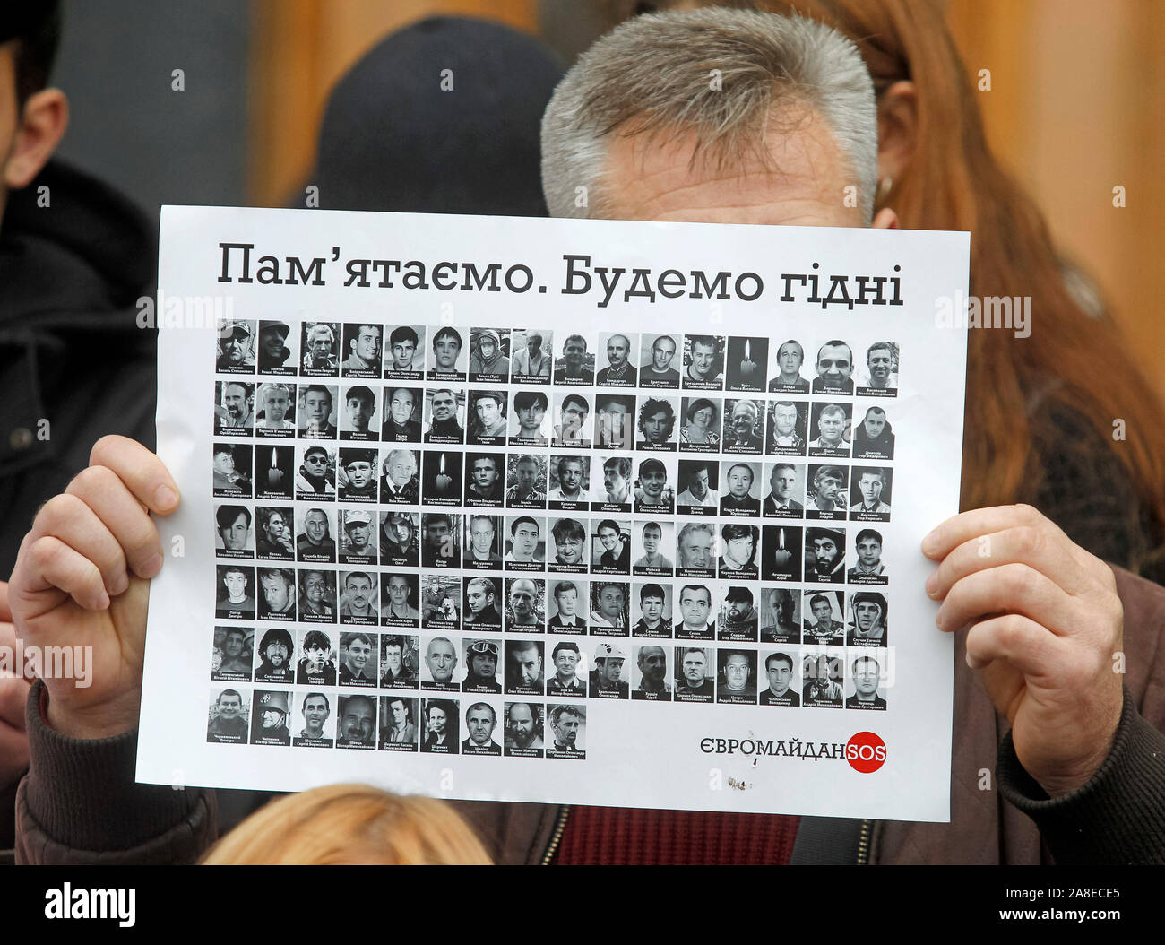 Ein Mann hält ein Schild mit Porträts von toten Aktivisten oder die Helden der Himmlischen Hundert, außerhalb des Präsidialbüros während des Protestes. Verwandte und Aktivisten, die Nachfrage nicht Untersuchung der Maidan bei Veranstaltungen und der Tod des Aktivisten während der Revolution der Würde oder Euromaidan zu stoppen. Am 21. November 2019 die Ukrainer werden der 6. Jahrestag des Maidan oder der Euromaidan Revolution 2013-14, bei der mehr als hundert regierungsfeindlichen Demonstranten getötet wurden und waren die Helden des Himmlischen Hundert betitelt. Stockfoto