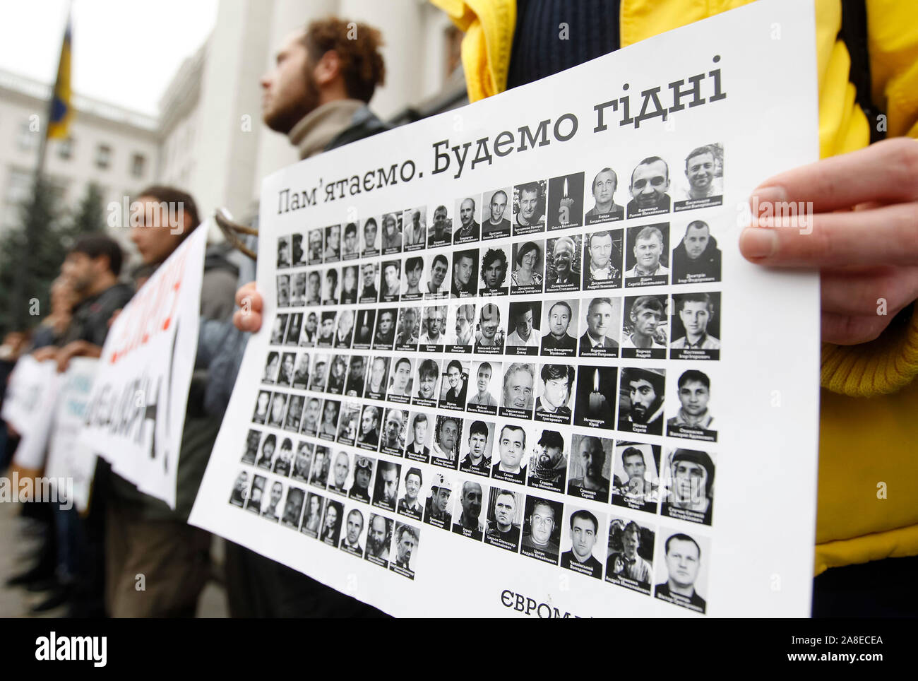 Ein Mann hält ein Schild mit Porträts von toten Aktivisten oder die Helden der Himmlischen Hundert, außerhalb des Präsidialbüros während des Protestes. Verwandte und Aktivisten, die Nachfrage nicht Untersuchung der Maidan bei Veranstaltungen und der Tod des Aktivisten während der Revolution der Würde oder Euromaidan zu stoppen. Am 21. November 2019 die Ukrainer werden der 6. Jahrestag des Maidan oder der Euromaidan Revolution 2013-14, bei der mehr als hundert regierungsfeindlichen Demonstranten getötet wurden und waren die Helden des Himmlischen Hundert betitelt. Stockfoto