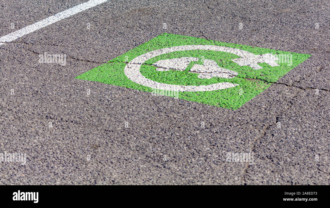 Eine grüne und weiße Symbol zeigt an, dass ein Punkt in einem Parkplatz ist nur für Elektrofahrzeuge, die in Rechnung gestellt werden kann. Stockfoto