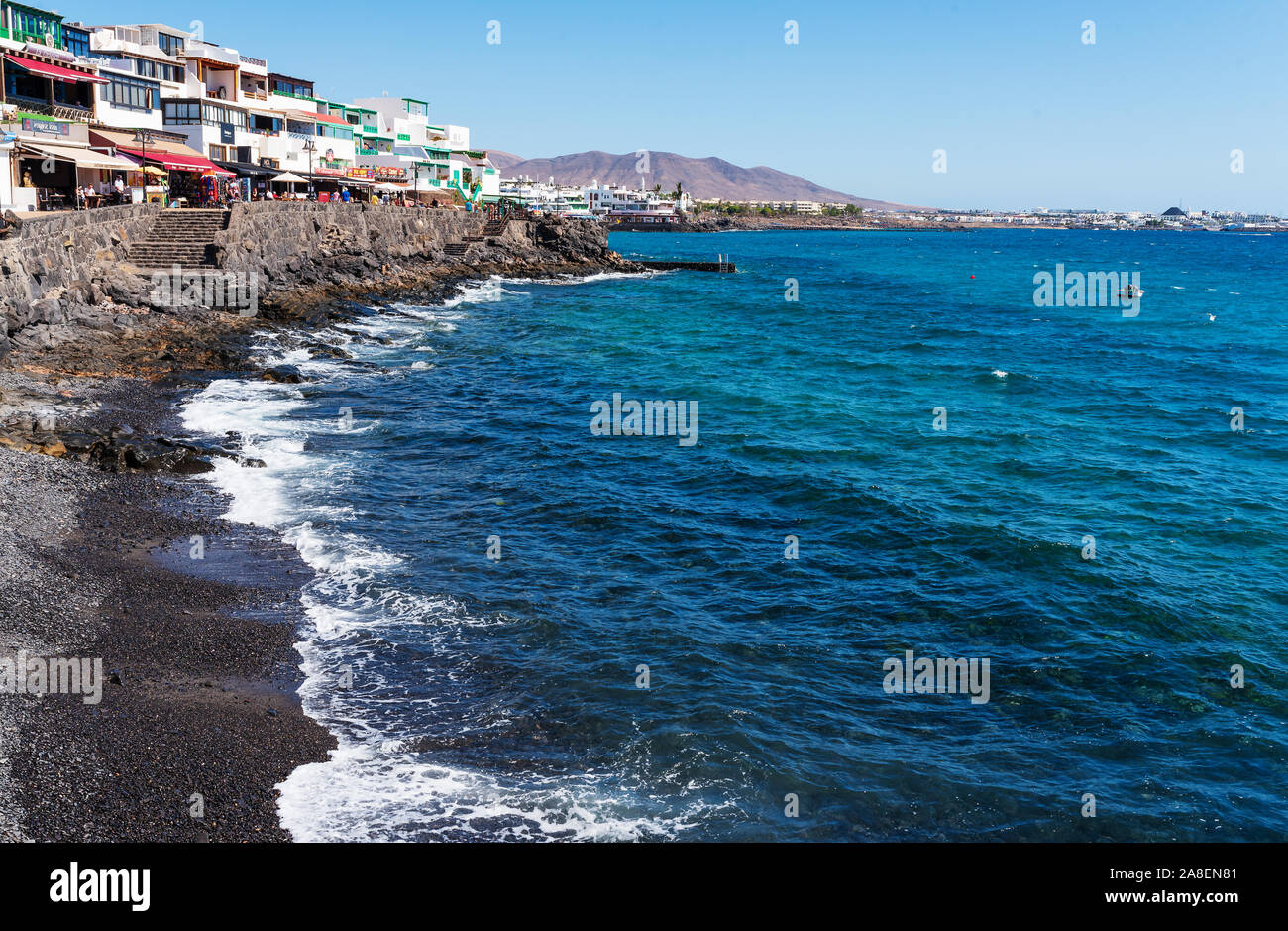 Playa Blanca, Kanarische Inseln, Spanien - Oktober 24, 2019: Boardwalk und die Uferpromenade von Playa Blanca, Lanzarote gegen Meer und blauer Himmel an einem sonnigen Tag Stockfoto