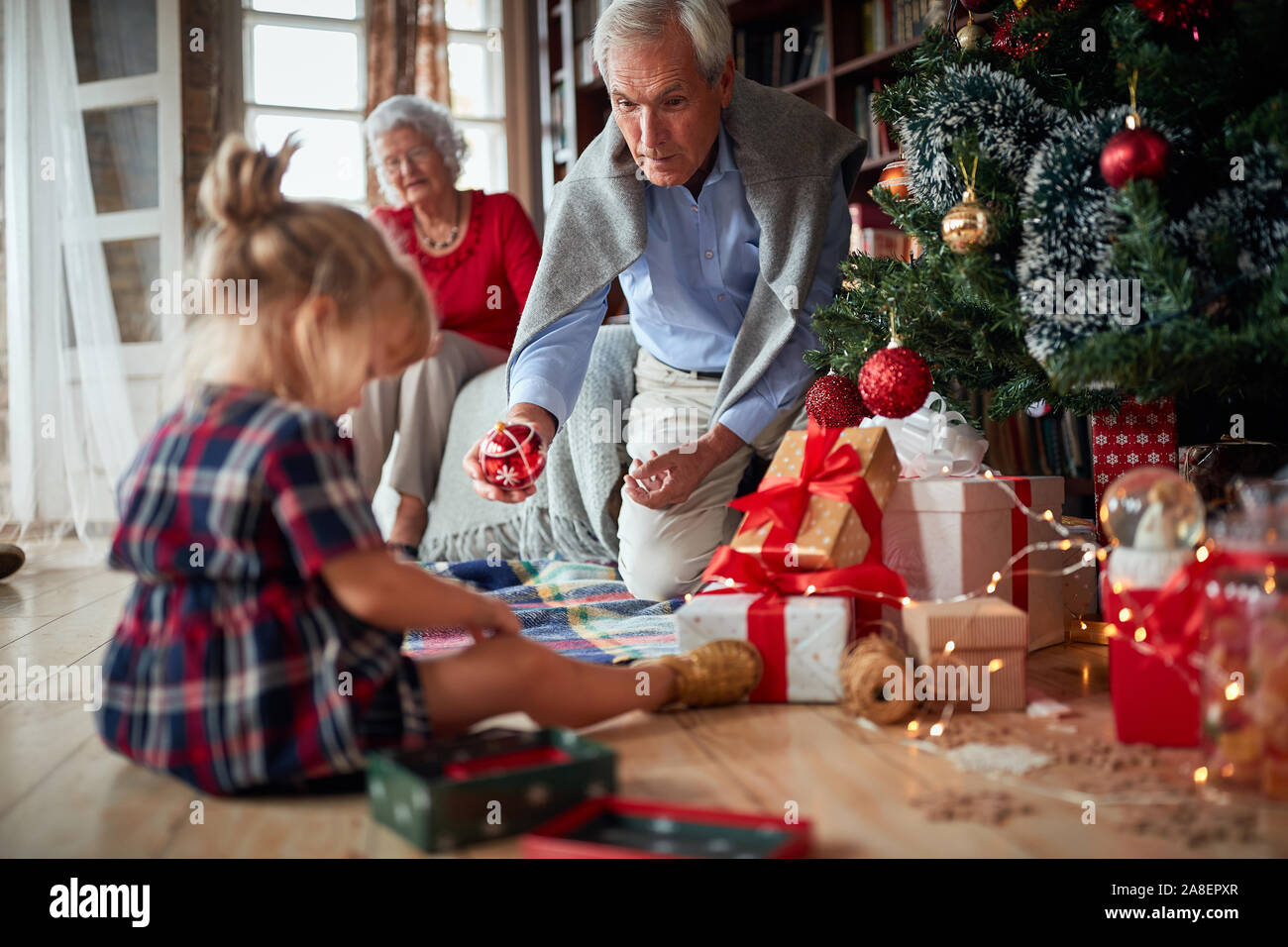 Gerne Großvater und Enkelin zusammen spielen für die Weihnachtsfeiertage Stockfoto