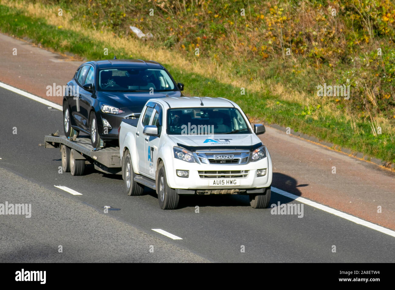 Isuzu D-Max Yukon Twin Turbo D/Abschleppen Auto auf Anhänger; Verkehr, Transport, moderne, Limousinen, Süd - auf die 3 spurige Autobahn M6 Autobahn gebunden. Stockfoto