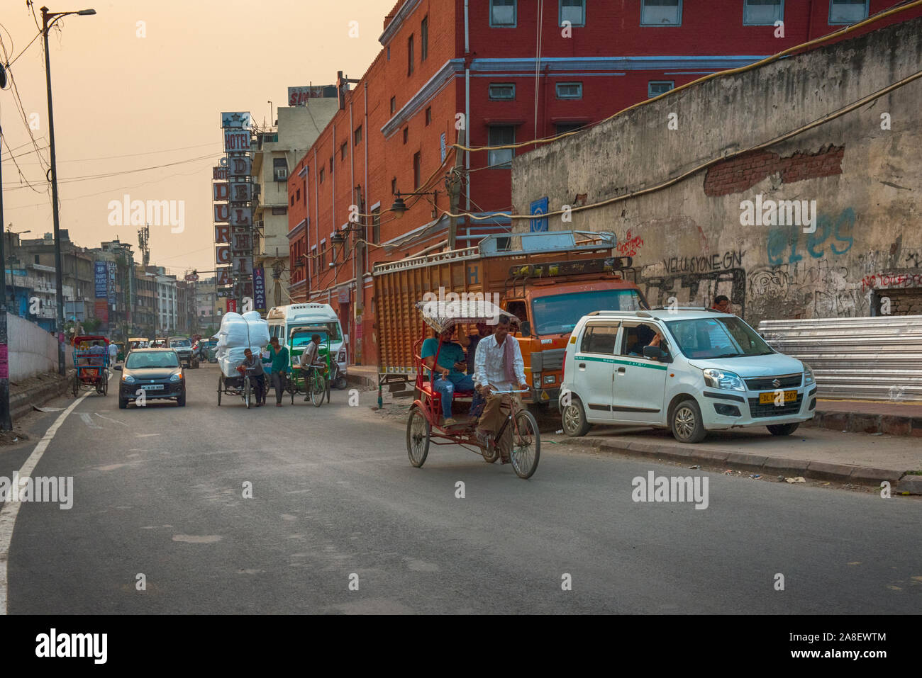 Autos, Rikschas und einem alten Fahrzeug bei Besetzt Neue Straße in Delhi am frühen Morgen Stockfoto