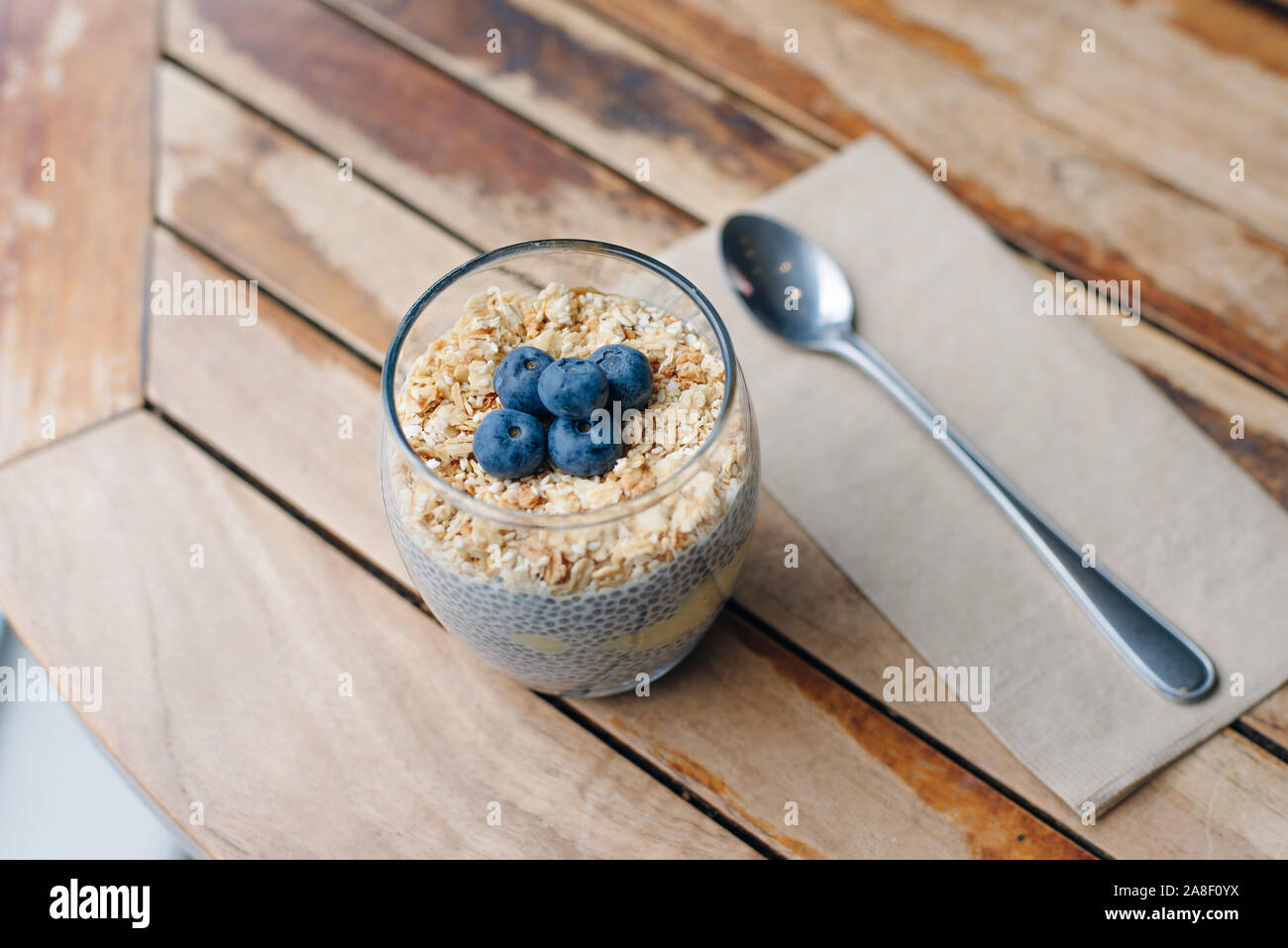 Blueberry yoghurt Parfait mit Müsli, Hafer und Chia Samen in ein Glas auf weissem Holztisch. gesundes Frühstück. Nach oben Schließen Stockfoto
