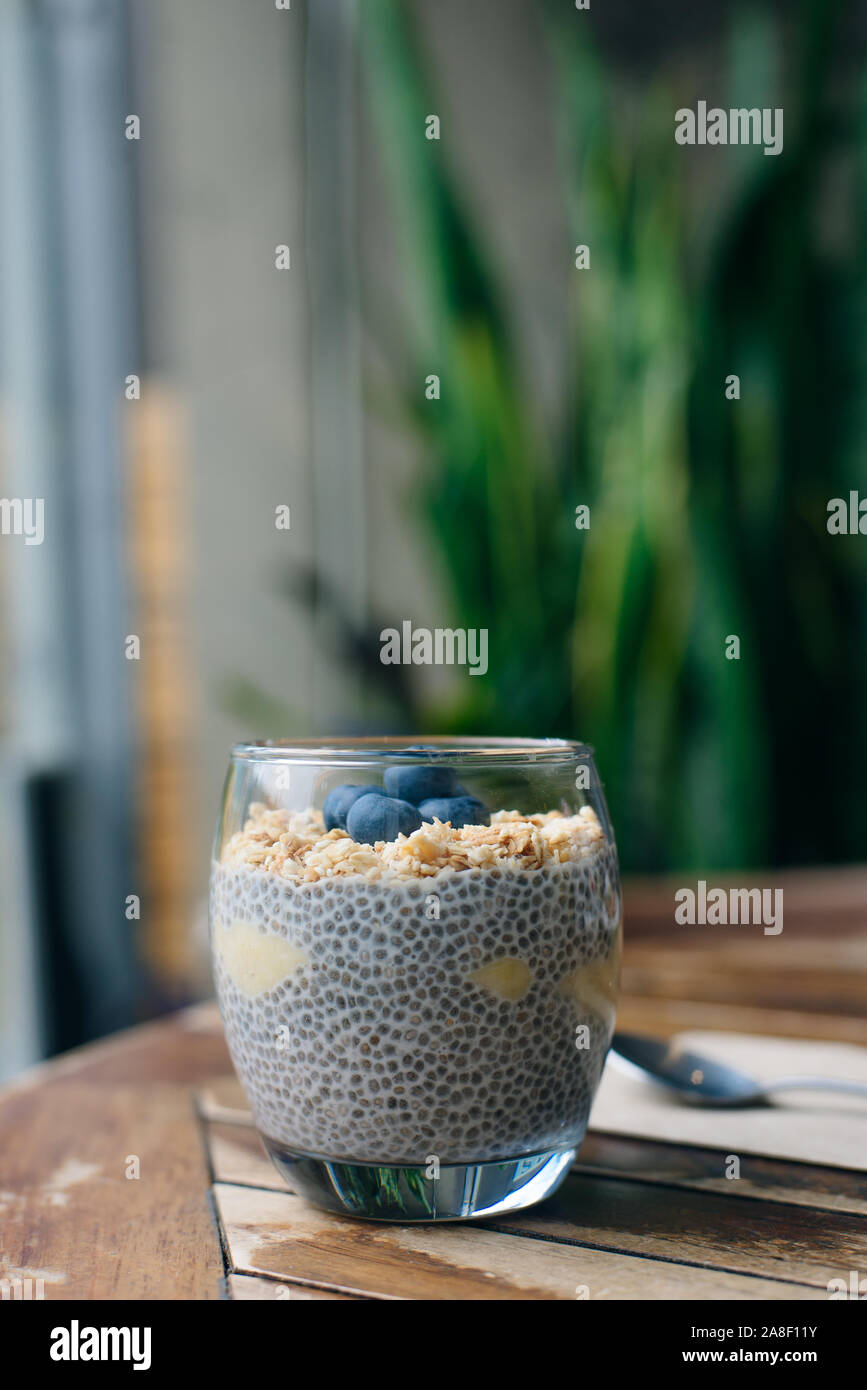 Blueberry yoghurt Parfait mit Müsli, Hafer und Chia Samen in ein Glas auf weissem Holztisch. gesundes Frühstück. Nach oben Schließen Stockfoto