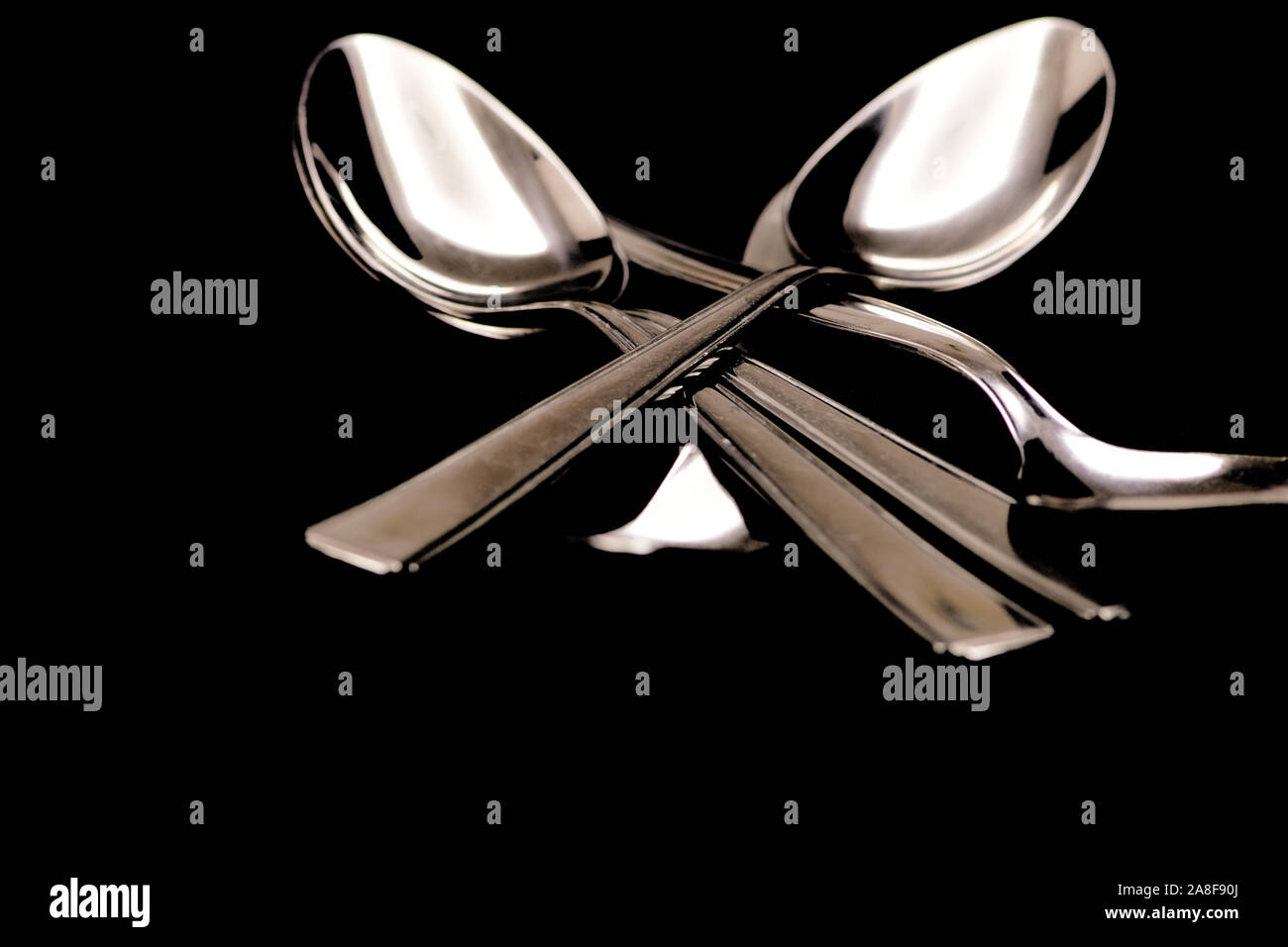 Löffel auf schwarzem Hintergrund Stockfoto