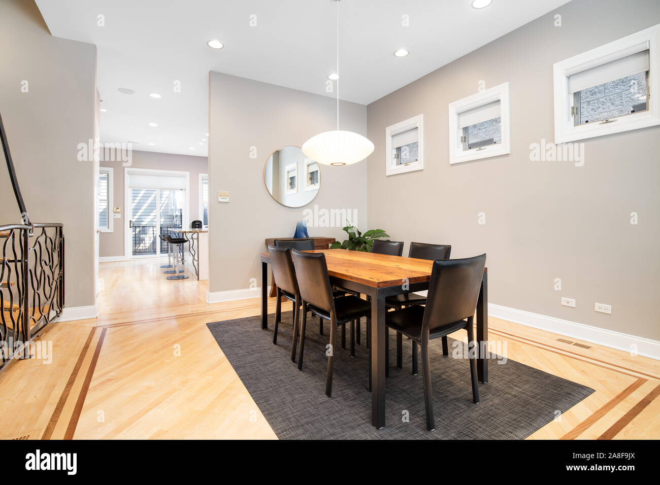 Ein luxuriöser Speisesaal, der mit dem Wohnzimmer verbunden ist. Dieses geräumige Bereich kann ein großer Tisch mit einem modernen Licht nach unten hängen über der Oberseite anbringen. Stockfoto
