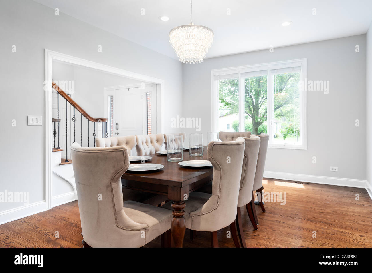 Ein luxuriöses Wohnzimmer mit einem Blick nach draußen. Dieses geräumige Bereich kann ein großer Tisch mit einem modernen Licht nach unten hängen über der Oberseite anbringen. Stockfoto