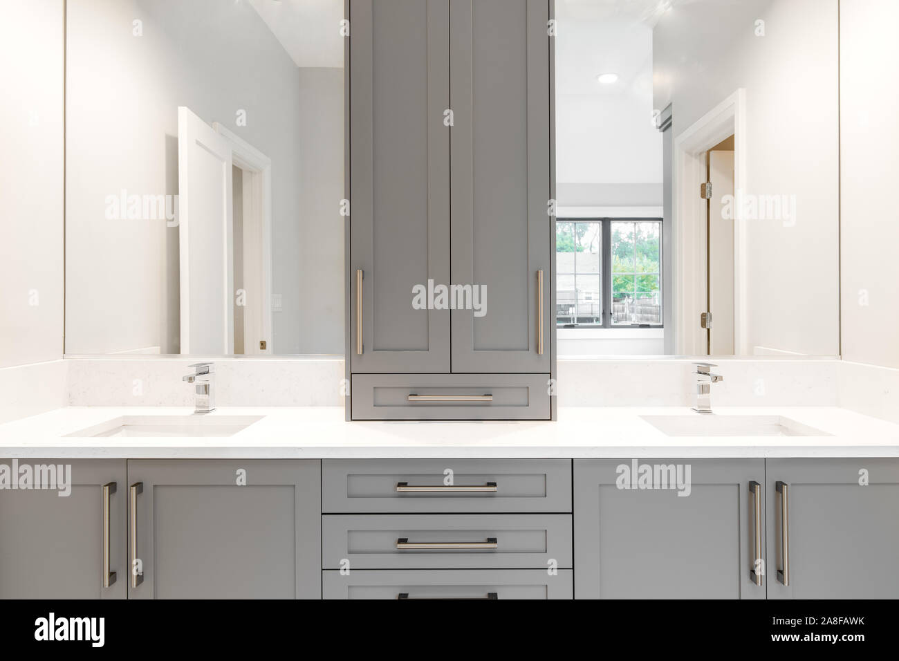 Ein graues Eitelkeit in einem großen luxuriösen Badezimmer mit Granit und Chromarmaturen. Stockfoto