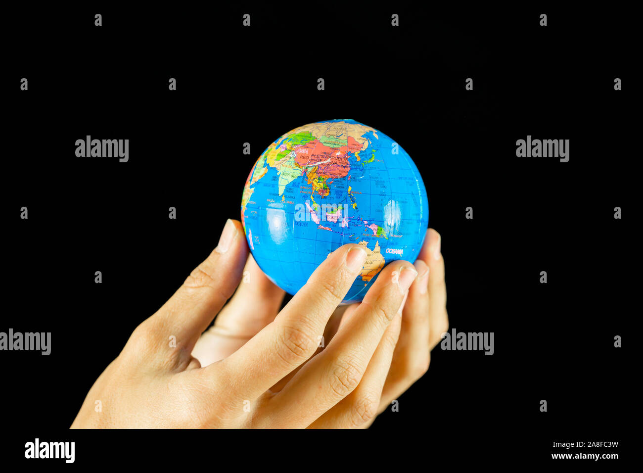 Männliche Hände halten die Erde Globus auf schwarzem Hintergrund Stockfoto
