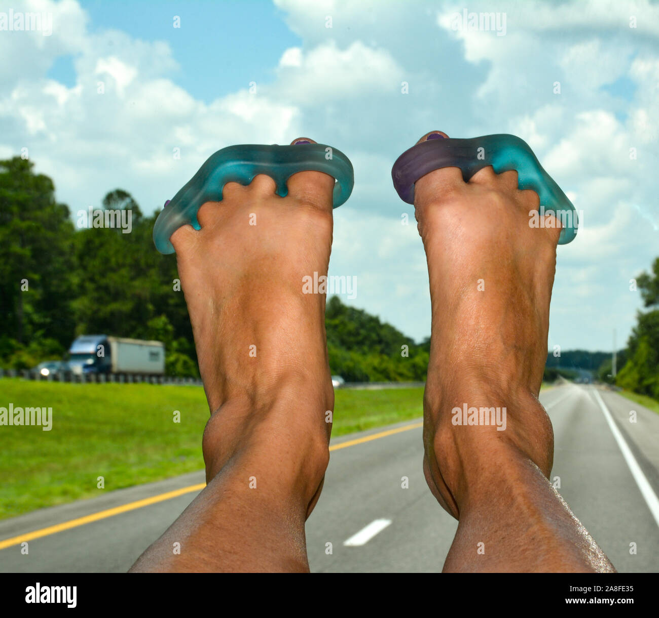 POV, Yoga toe Krankentragen mit angehobenen Füßen auf dem Armaturenbrett sind für die reisende Passagier in RV, nach unten gehen, ein Florida Highway Stockfoto