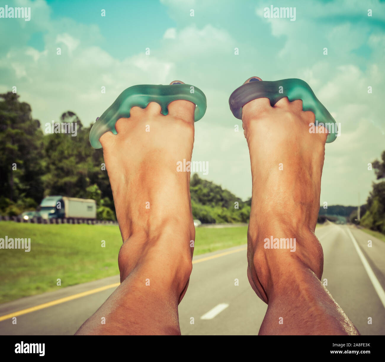 POV, Blau yoga toe Krankentragen mit angehobenen Füßen auf dem Armaturenbrett sind für die reisende Passagier in RV, nach unten gehen, ein Florida Highway Stockfoto