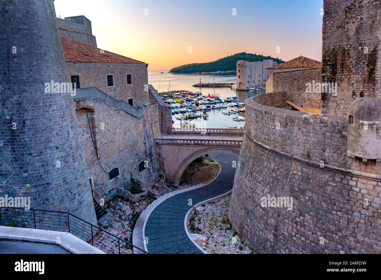 Alte Stadtmauer und den alten Hafen von Dubrovnik bei Sonnenuntergang in Dubrovnik, Kroatien Stockfoto