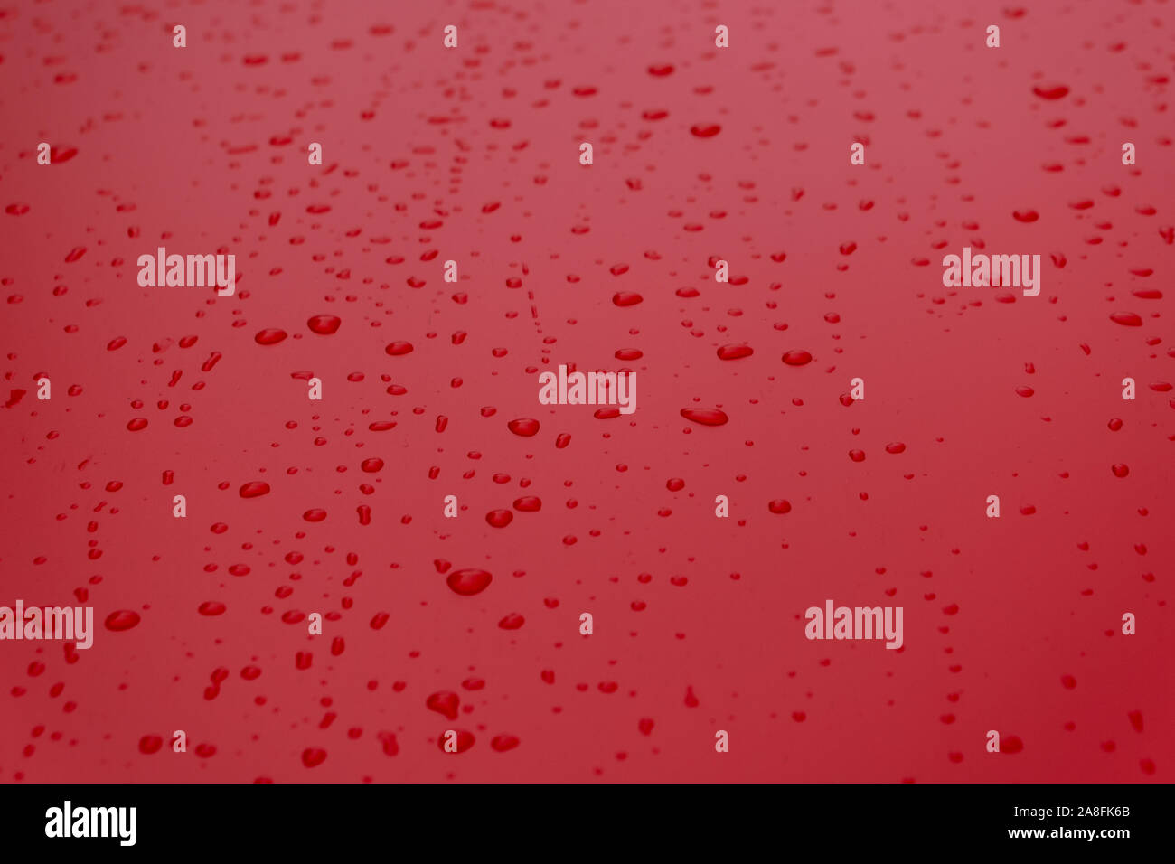 Rotes Wasser fällt auf Glas Stockfoto