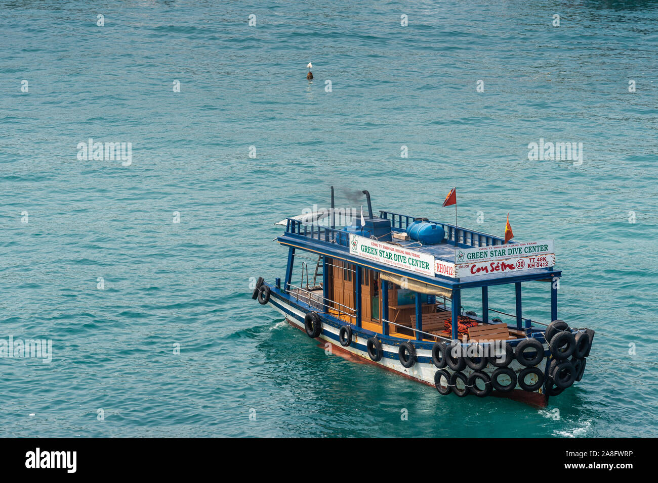 Nha Trang, Vietnam - März 11, 2019: Nahaufnahme von traditionellen Grün Star Dive Center Boot sitzen auf azurblauem Wasser. Stockfoto