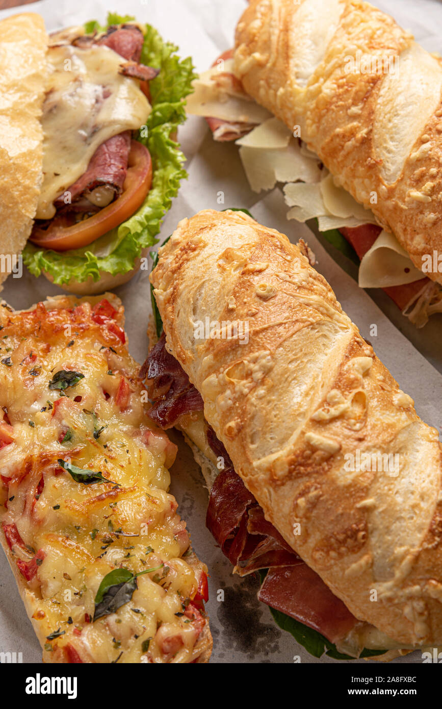 Satz von verschiedenen Sandwiches mit Käse, Salat von letucce und Tomaten auf Holzuntergrund Stockfoto