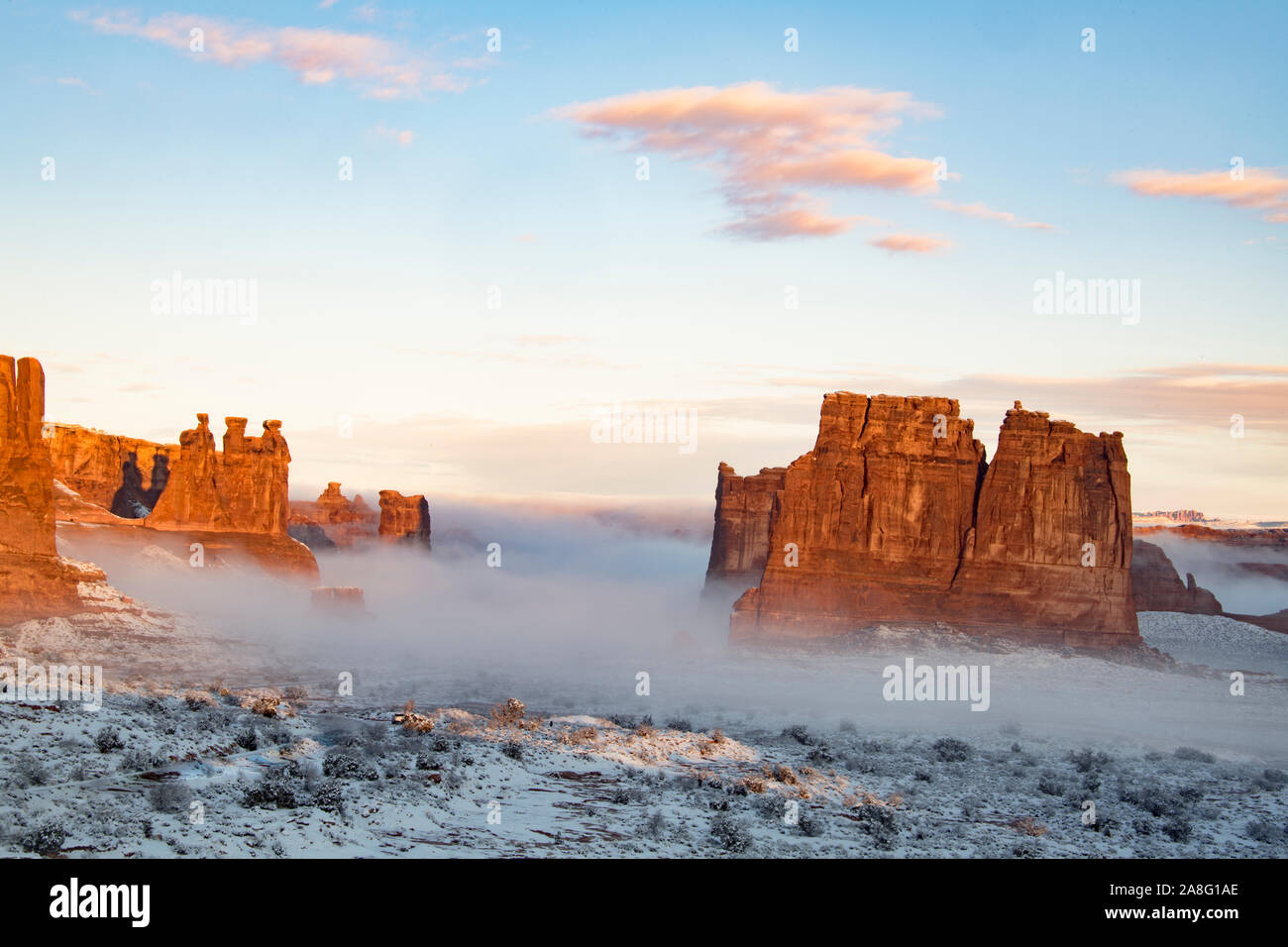 Nebel im Winter Dawn, Arches National Park, Utah. Drei Klatschbasen, Schafe Rock, Courthouse Towers Stockfoto