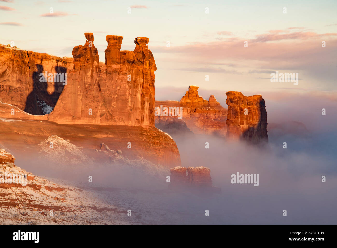 Nebel im Winter Dawn, Arches National Park, Utah. Drei Klatschbasen, Schafe Rock Stockfoto