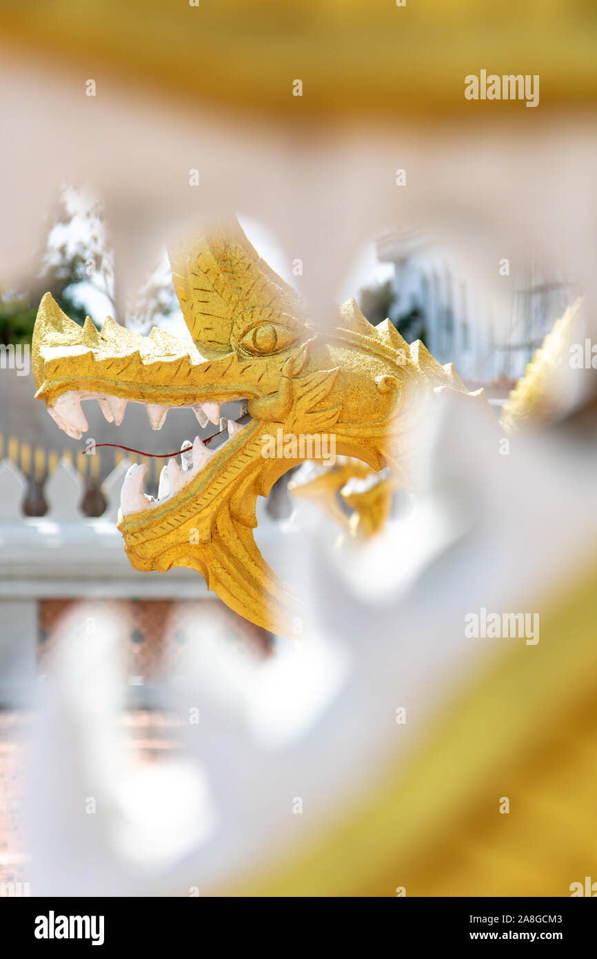 Blick auf die vergoldeten Statue von Naga - Drache durch die Zähne im Kiefer eines anderen Naga. Stockfoto
