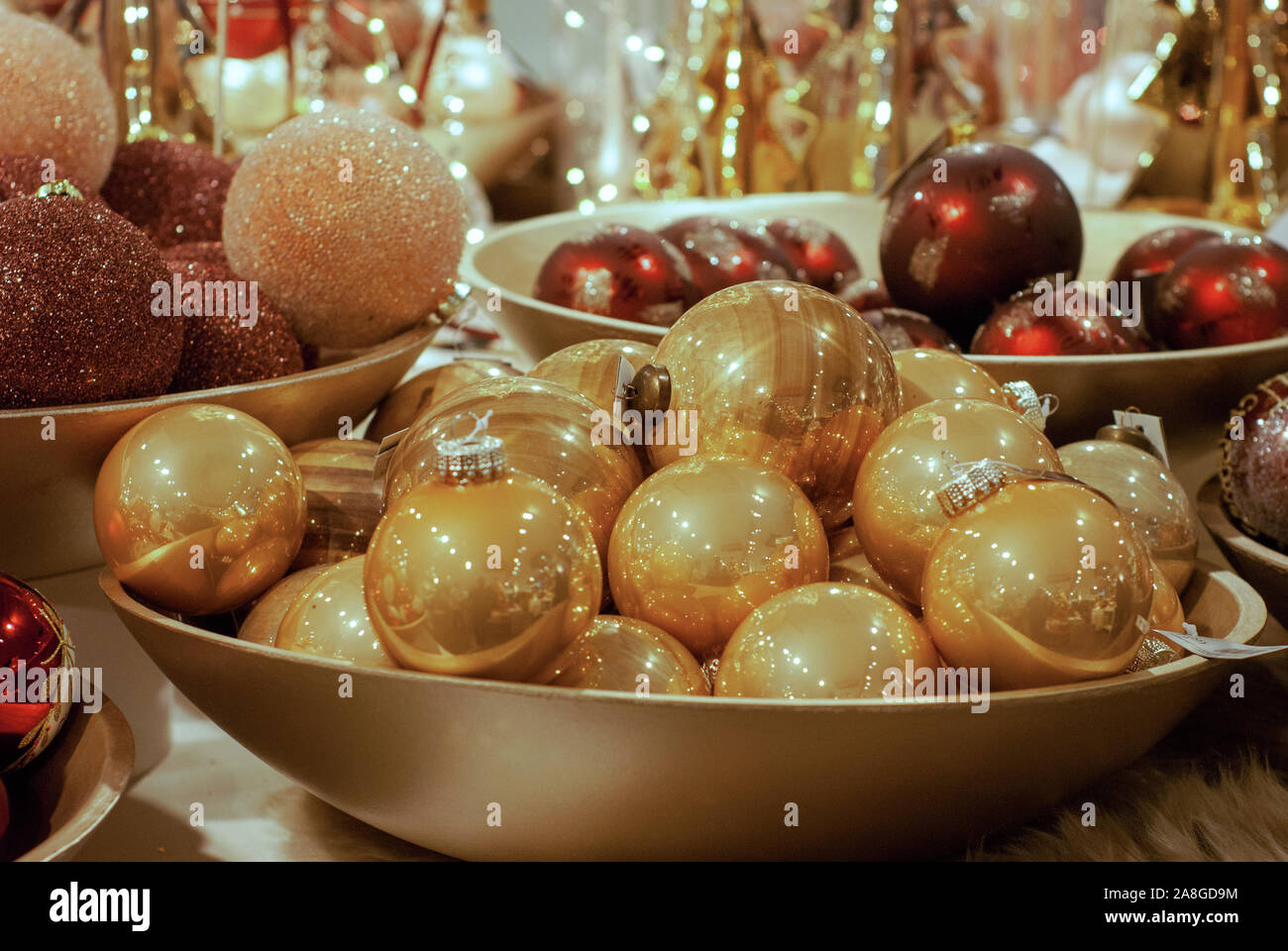 Weihnachten Deko Kugel: Rot und Gold Farbe von Weihnachten Kugeln in der Schüssel. Dekoration für Weihnachten und Neujahr Urlaub Partei. Festliche Lichter Hintergrund Stockfotografie