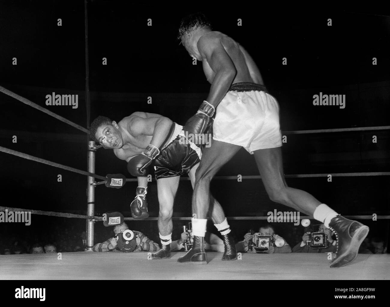 Leichte Boxing champion Joe Brown schlägt Challenger Joey Lopes während eines Spiels im Chicago Stadium im Dezember 1957. Stockfoto