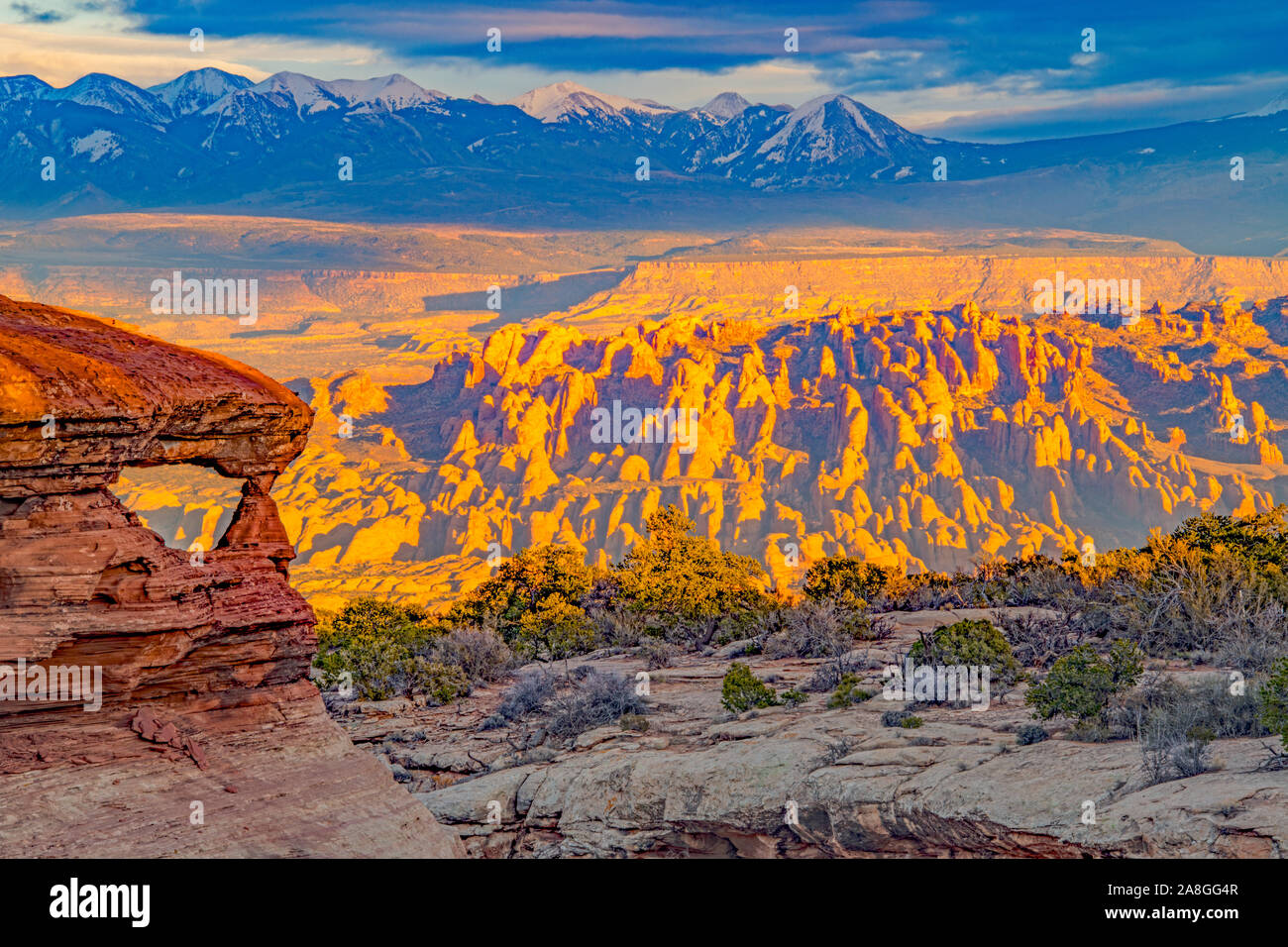 Bogen mit La Sal Mountains und hinter den Felsen bei Sonnenuntergang Colorado River Canyons in der Nähe von Moab, Utah Stockfoto