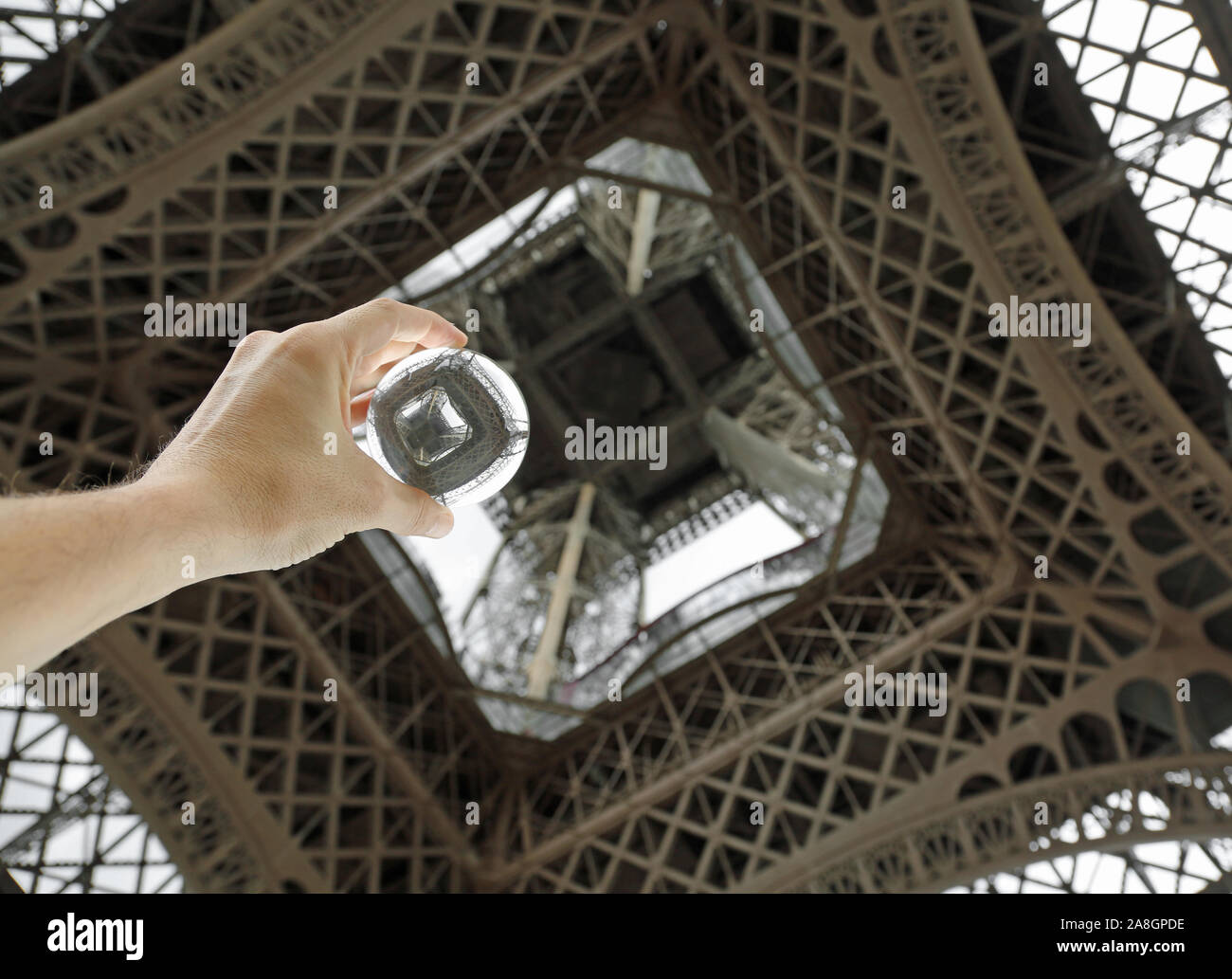 Kugel aus Glas unter dem Eiffelturm auf die Hand des Menschen Stockfoto