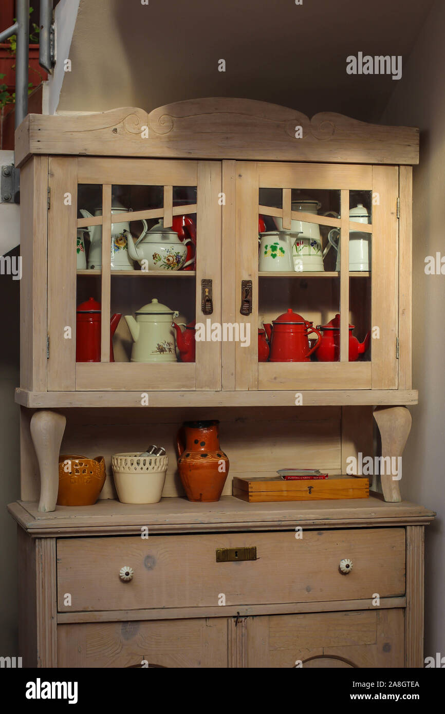 Küche aus Holz Schrank mit weißen und roten Zinn Krüge und Kessel Stockfoto