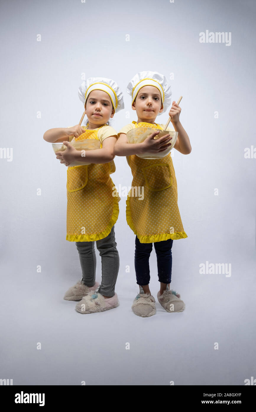 Junge Schwestern, Backen eines Kuchens zusammen im Studio Stockfoto