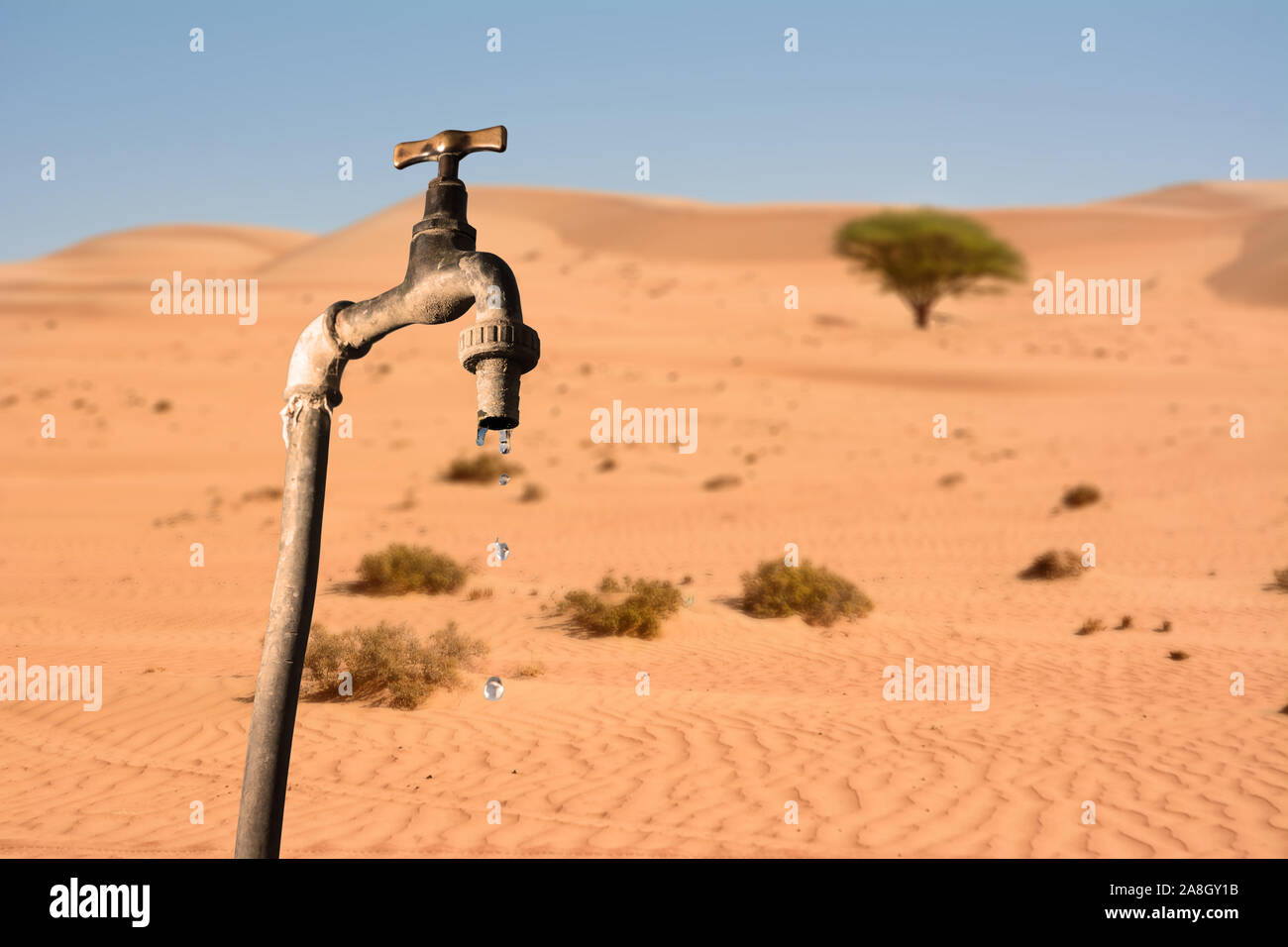 Tropfenden Hahn und Umwelt Wüste im Hintergrund, Konzept der globalen Erwärmung Planet und Wasserknappheit Stockfoto