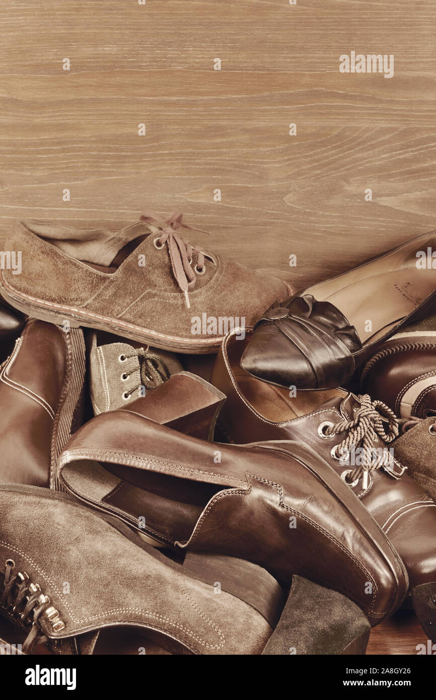 Gruppe der alten Schuhe verschiedene Modelle und ein Text auf Holz- Hintergrund Stockfoto