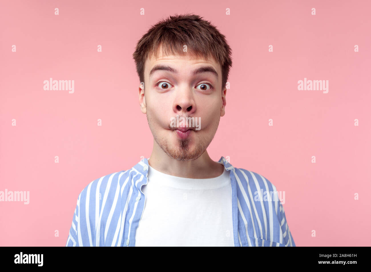 Portrait von lustigen braunhaarige Mann mit dem kleinen Bart und Schnurrbart in lässig-gestreiften Hemd, Fisch Gesicht mit Lippen -, kindisch und dumm schauen. Stockfoto