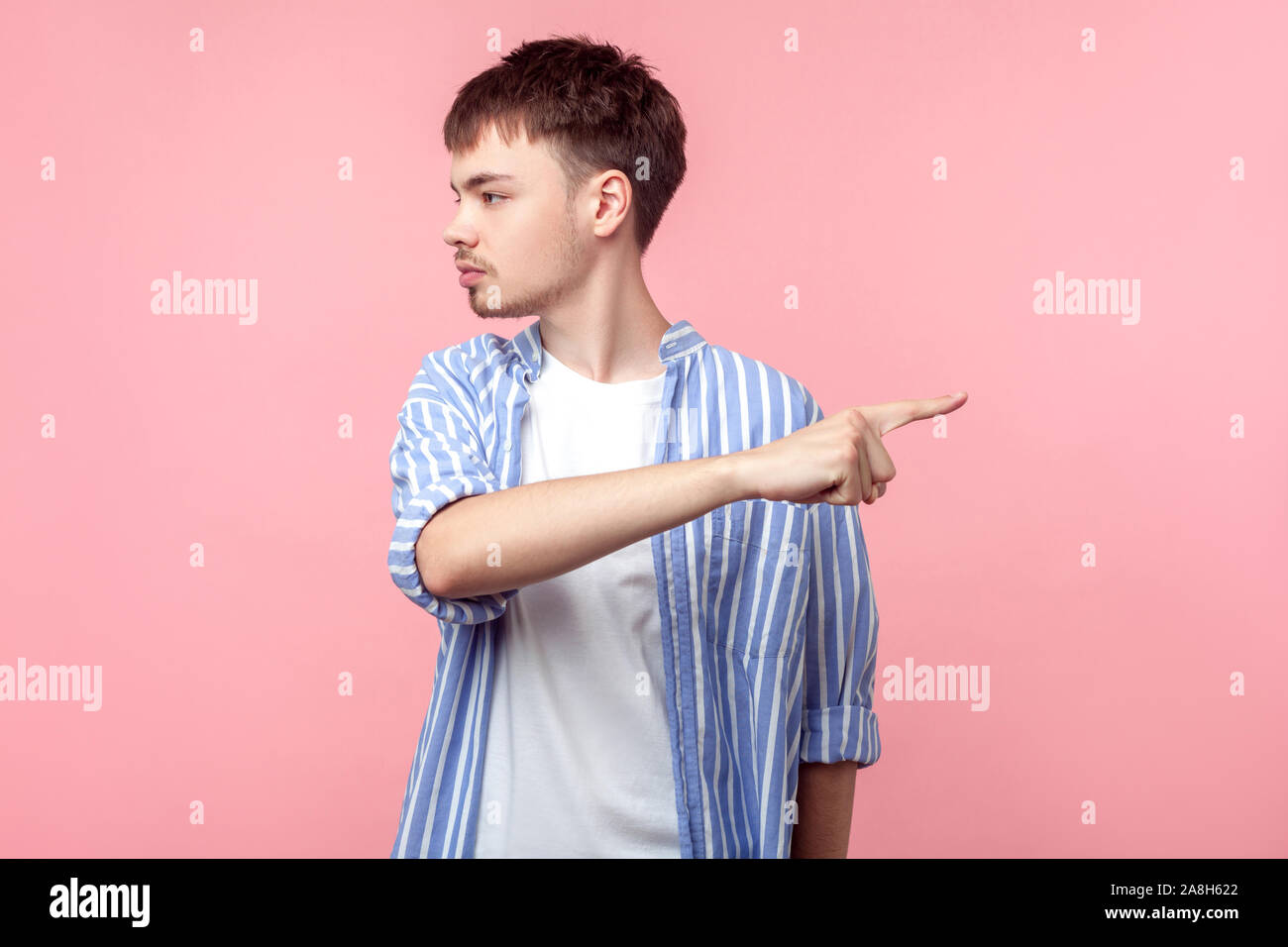 Verschwinde! Portrait von gereizt wütend braunhaarige Mann mit dem kleinen Bart und Schnurrbart in casual Shirt beiseite und Zeigefinger einen anderen Weg. ind Stockfoto