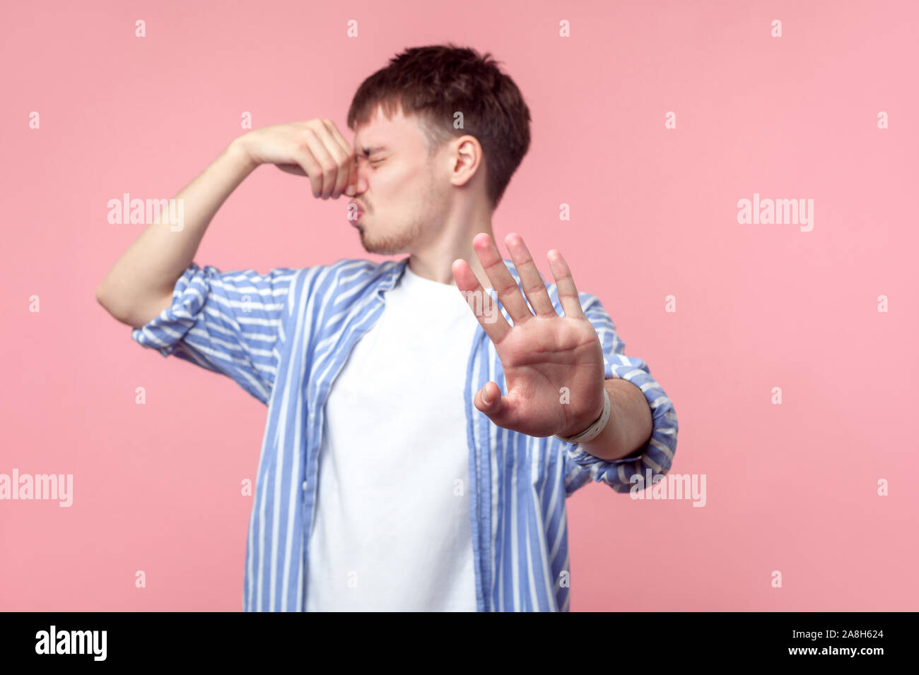 Diese schlechten Geruch stoppen! Portrait von verärgert pissed braunhaarige Mann mit dem kleinen Bart in casual Shirt seine Nase kneifen, angewidert mit unangenehmen Odo Stockfoto