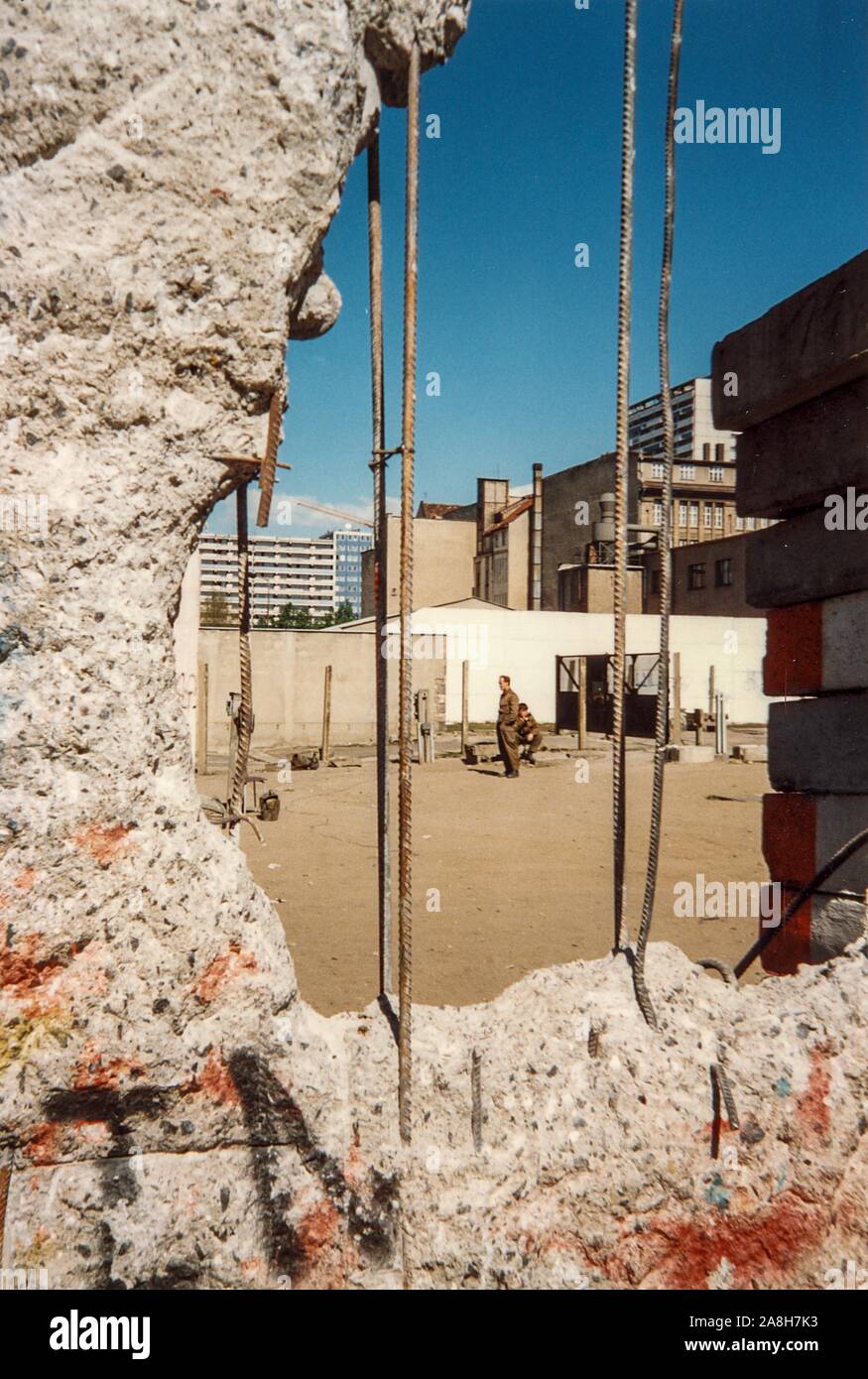 Michael Scott/Alamy Live Nachrichten - Berlin, Deutschland April 1990 - DDR-Soldaten noch auf bezahlten Pflicht, obwohl die Mauer fiel Monate vor. Durch ein Loch in der Wand fotografierte im April 1990 Monate nach dem Fall der Berliner Mauer im Jahr 1989. Stockfoto